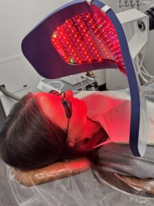 a woman lying on a bed with red light